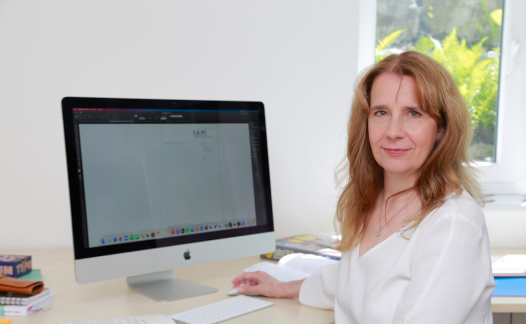 Designagentur Silke Wengenroth-Lippke am Schreibtisch vor dem Computer